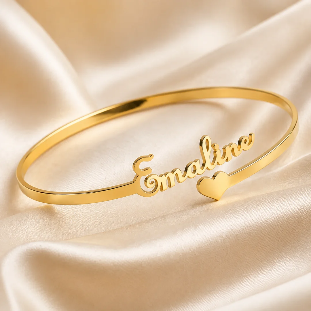 Customized gold name kada bracelet displayed on cream satin
