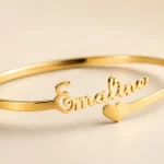 Close-up of customized gold name kada with Emaline script and heart