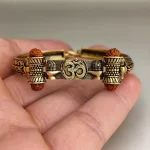 Gold Plated Shivlinga Om Trishul Rudraksha Bracelet held in hand close-up