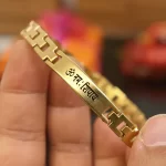 Om Namah Shivay Gold Bracelet held in hand close-up