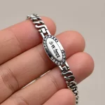 Silver-Plated Oval Om Namah Shivay Bracelet held in hand close-up