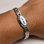 Silver-Plated Oval Om Namah Shivay Bracelet worn on a men's wrist