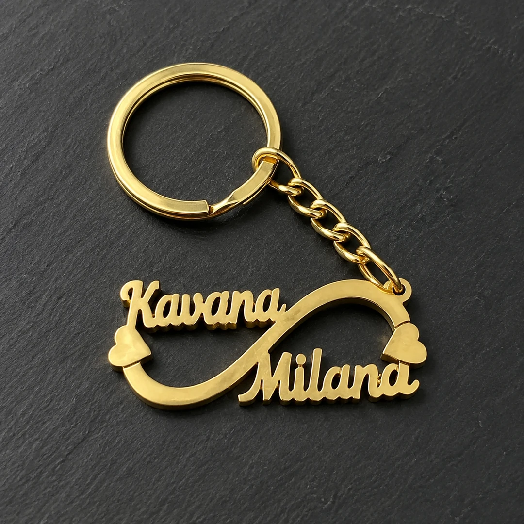 Double Name Infinity Keychain in gold brass on a black stone background